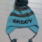 STRIPE EARFLAP WITH NAME AND POMPOM