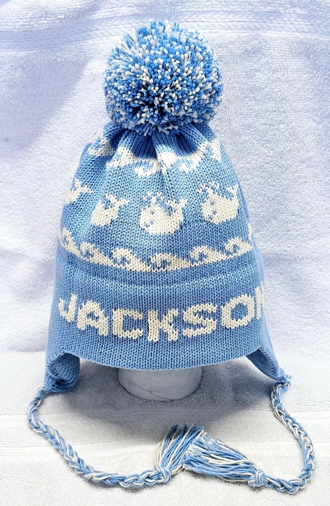 EARFLAP HAT WITH DESIGN AND POMPOM