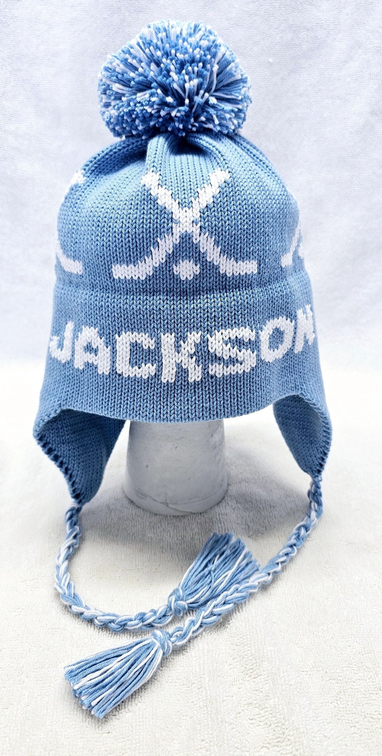 EARFLAP HAT WITH DESIGN AND POMPOM